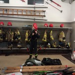 Strażak zakłada specjalny ochronny strój