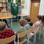 Uczniowie klasy drugiej poznają historię smoka oglądając teatrzyk kamishibai