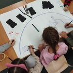 Uczniowie klas drugich wspólnie tworzą plakat pod hasłem Ratujmy Ziemię