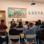 Uczniowie klasy siódmej poznają historię smoka oglądając teatrzyk kamishibai