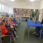 Dzieci z grupy przedszkolnej oglądają teatrzyk kamishibai