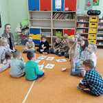 Dzieci na dywanie rozwiązują zagadki 