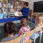Pani bibliotekarka prezentuje przedszkolakom książkę popularno - naukową 