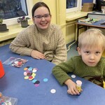 Uczennica z klasy 5 A pomaga uczestnikowi dnia otwartego w wykonaniu opaski z imieniem
