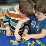 Chłopcy z klasy I B układają puzzle