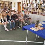 Uczniowie z klasy pierwszej słuchają opowieści o książkach