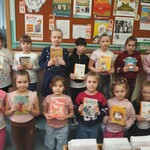 Dziewczynki z klasy I A prezentują swoje pierwsze książki wypożyczone w bibliotece szkolnej
