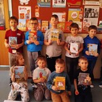 Chłopcy z klasy I B prezentują swoje pierwsze książki wypożyczone w bibliotece szkolnej