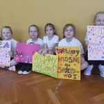 Dziewczynki trzymają plakaty Wiosna na sportowo i Witamy wiosnę