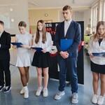 Uczniowie z klasy 7 A recytują wiersze w tle prezentacja multimedialna