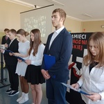 Uczniowie z klasy 7 A recytują wiersze w tle prezentacja multimedialna