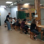 Pracownik strzelnicy nadzoruje uczniów podczas strzelania