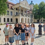 Uczniowie spacerują po parku przed pałacem
