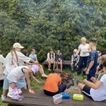 Uczniowie klas czwartych z wychowawczynią pieką kiełbaski na ognisku