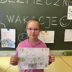 Uczennica z klasy 2 A prezentuje plakat na temat bezpieczeństwa