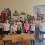 Klasa  4 b prezentuje się na tle czerwonej budki telefonicznej