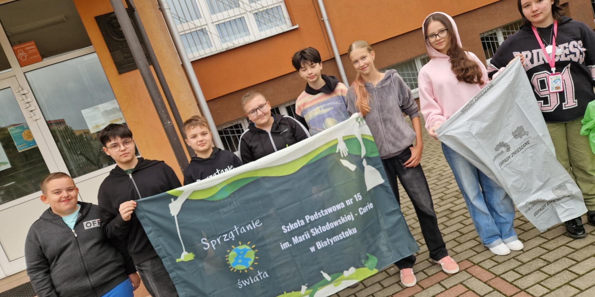 Uczniowie klasy 7 B trzymają baner promujący Akcję Sprzątania Świata.jpg