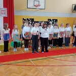 Występ chóru dzieci trzymają kartoniki z napisem dziękujemy