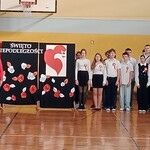 Nauczyciele i uczniowie śpiewają hymn 