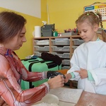 Pani gipsuje dziewczynce palec.
